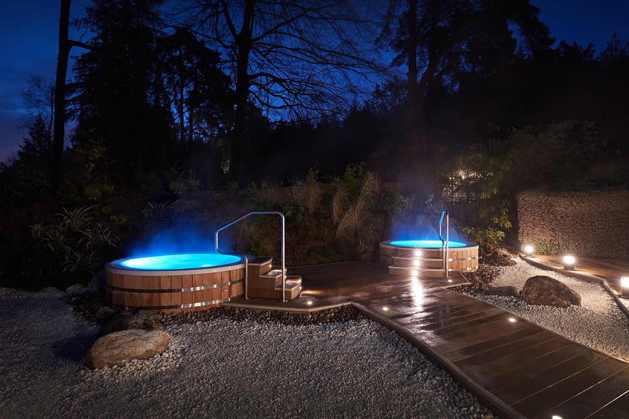 Steaming hot tubs in the Hot Springs Garden at night.